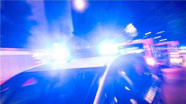 Ein Streifenwagen der Polizei steht mit Blaulicht an einem Einsatzort.
