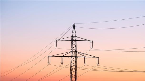 Ein Strommast bei Sonnenaufgang.