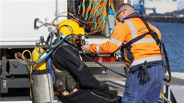 Ein Taucher machte sich im Rostocker Hafen startklar, um den Rumpf des nach einem Brand havarierten Öltankschiffes „Annika“ zu kontrollieren.
