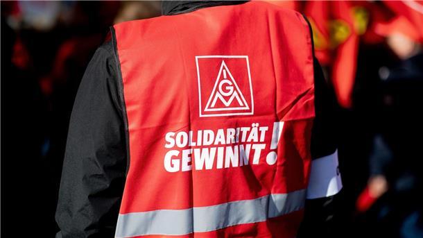Ein Teilnehmer einer Kundgebung der IG Metall trägt eine rote Weste mit der Aufschrift „Solidarität gewinnt!“.