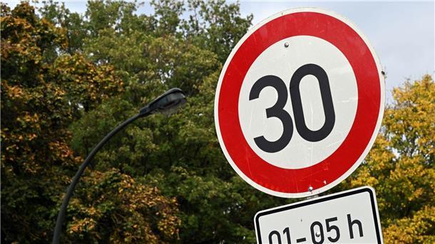 Ein Tempo 30-Schild steht an einer Straße.