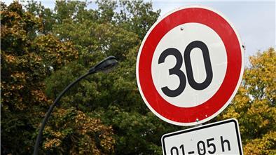 Ein Tempo 30-Schild steht an einer Straße.