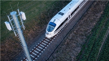 Ein Testzug der Deutschen Bahn fährt an einer der Antennenmasten für das 5G-Bahnprojekt vorbei.