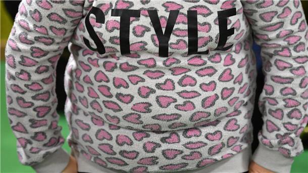 Ein übergewichtiges Kind trägt einen Pulli mit dem Schriftzug „Style“.