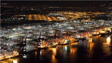 Ein Unterschied wie Tag und Nacht: Der Nordhafen liegt noch unter gelblichem Licht aus Natriumdampflampen, während der Containerterminal in hellem LED-Weißlicht erstrahlt.