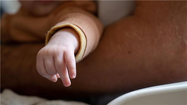 Ein Vater trägt seine Tochter auf dem Arm.