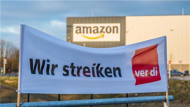 „Make Amazon pay!“: Beschäftigte demonstrieren für mehr Geld Ein Verdi Banner mit der Aufschrift: „Wir streiken“ steht vor dem Amazon-Logistik-Zentrum.