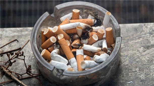Wirbel im Kampf gegen Tabak: Verbot von Filtern und Aroma? Ein voller Aschenbecher steht auf einem Fensterbrett.
