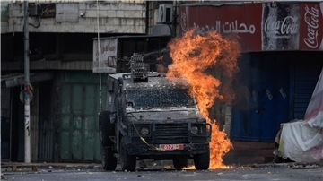 Ein von einem palästinensischen Demonstranten geworfener Molotowcocktail explodiert auf einem israelischen gepanzerten Fahrzeug in Nablus.
