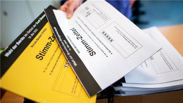 Wahlbeteiligung in Bremen am Nachmittag schlechter als 2019 Ein Wahlhelfer gibt in einem Wahllokal die Stimmzettel für die Bürgerschaftswahl und die Kommunalwahl an die Wähler aus.