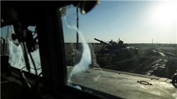 Ein zerstörter Panzer ist durch das Fenster eines Fahrzeugs an der Frontlinie in der Nähe von Klischtschijiwka bei Bachmut zu sehen.