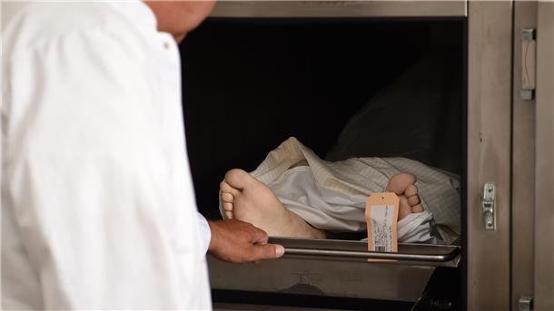 Ein Rechtsmediziner verschließt in der Pathologie eine Kühlkammer. 