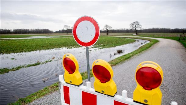 Ausfall der Müllabfuhr wegen Hochwassers im Kreis Oldenburg Eine Absperrbake steht in der Huntemarsch auf einem Feldweg.