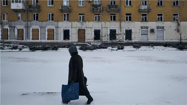 Eine Anwohnerin geht in Bachmut an enem beschädigten Gebäude vorbei. In der Stadt halten sich laut Behördenangaben noch knapp 5000 Zivilisten auf.