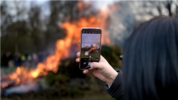 Eine Besucherin filmt ein Osterfeuer - so friedlich verhielten sich offenbar alle.
