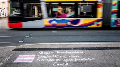 Eine Bremer Straßenbahn fährt an einer Protestbotschaft vorbei, die Gewalt gegen transidente Personen verurteilt. In so einer Straßenbahn war es am 3. September zu dem Angriff auf eine transidente Frau gekommen.