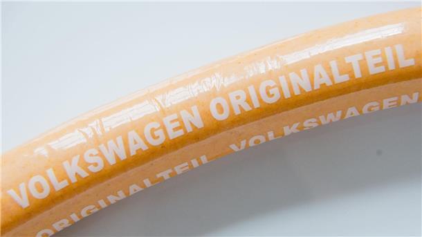 Die VW-Currywurst kehrt zurück Eine Currywurst mit Aufschrift „Volkswagen Originalteil“ liegt auf einem Teller.