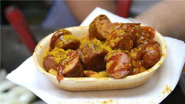 Einladungen zu Currywurstessen: Staatsanwaltschaft ermittelt Eine Currywurst wird in einer essbaren Schale verkauft.