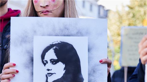 100 Tage nach Jina Mahsa Aminis Tod: Teheran in der Krise Eine Demonstrantin hält in Berlin eine Abbildung der getöteten Kurdin Jina Mahsa Amini in die Höhe.