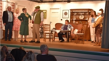 Schauspielerinnen und Schauspieler stehen auf der Bühne. 
