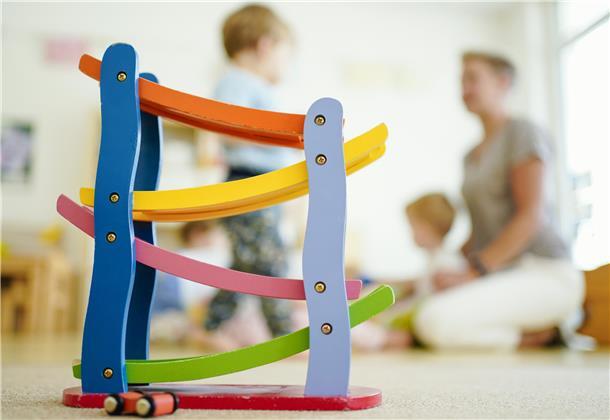 Eine Erzieherin spielt in einer Kita mit Kindern. (