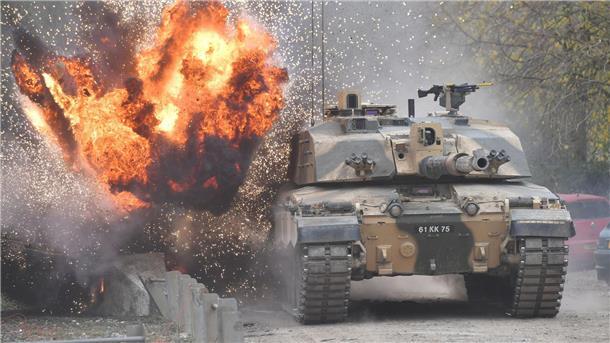 Eine Explosion ereignet sich in der Nähe eines Kampfpanzers vom Typ Challenger 2.