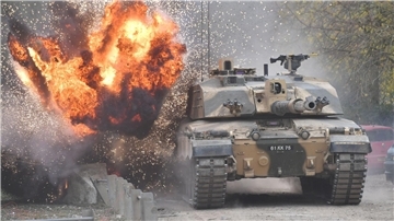 Eine Explosion ereignet sich in der Nähe eines Kampfpanzers vom Typ Challenger 2.
