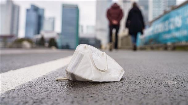 Eine FFP2-Maske liegt auf dem Gehweg der Frankfurter Untermainbrücke.