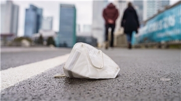 Eine FFP2-Maske liegt auf dem Gehweg der Frankfurter Untermainbrücke.