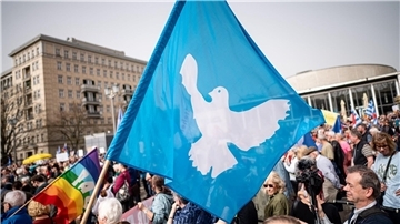 Eine Flagge mit der Friedenstaube ist auf dem traditionellen Ostermarsch in Berlin zu sehen.