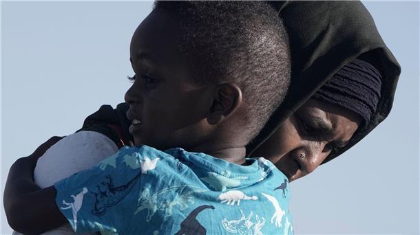 Konflikt im Sudan: Kämpfe gehen trotz Waffenruhe weiter Eine Frau aus dem Sudan trägt ihren Sohn, während sie von Bord der USNS Brunswick gehen.