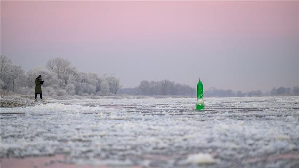 Eine Frau fotografiert den Eisgang auf der Elbe im niedersächsischen Neu Darchau.