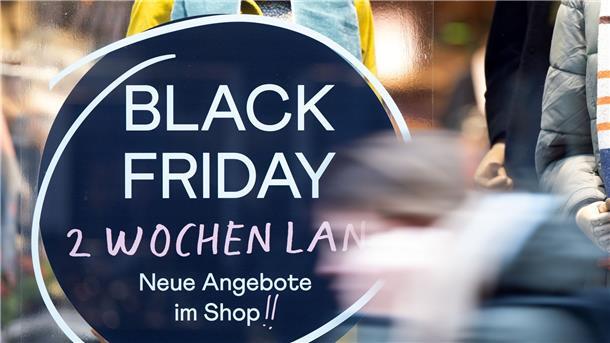 Inflation und knappe Kassen: Dunkle Wolken am Black Friday Eine Frau geht an einem Geschäft vorbei, das mit Black Friday-Angeboten wirbt.