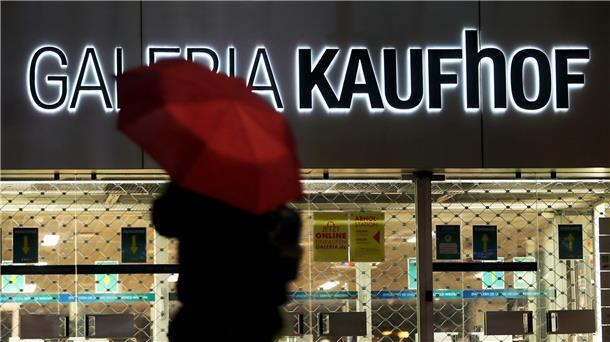 Galeria-Schieflage: Forderungen nach Benko-Beteiligung Eine Frau geht mit Regenschirm an einer geschlossenen Kaufhof Filiale vorbei.