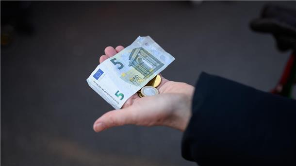 Niedersächsische Wirtschaft 2022 um 1,1 Prozent gewachsen  Eine Frau hält das Bargeld für ihren Einkauf in der Hand bereit.