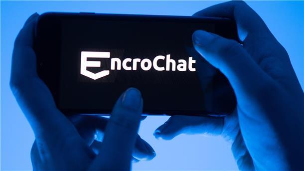Eine Frau hält ein Smartphone mit dem Logo des Krypto-Messengerdienstes Encrochat.