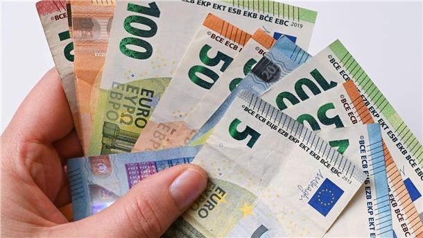 Eine Frau hält Geldscheine in der Hand.