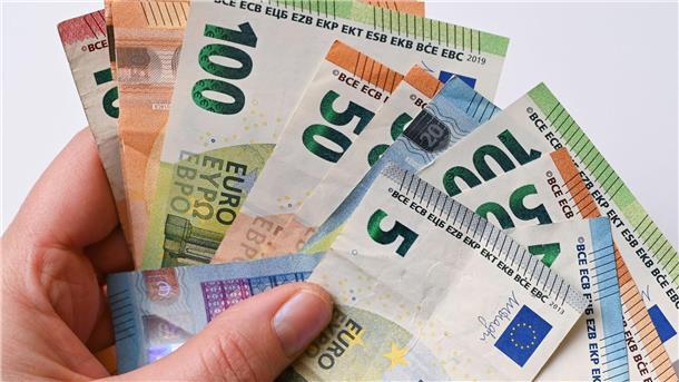 Eine Frau hält Geldscheine in der Hand.