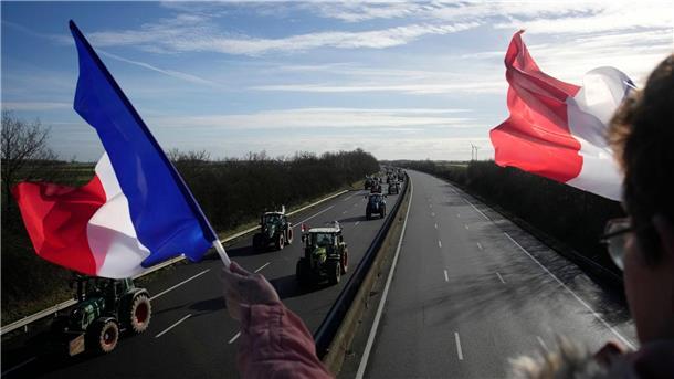 Frankreich macht Bauern Zusagen - Blockaden rund um Paris Eine Frau jubelt Landwirten mit französischen Fahnen zu.