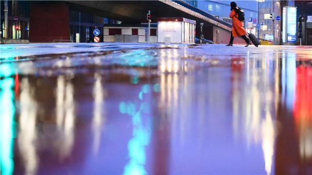 Pegel sind wieder gestiegen: Mildes Wochenende erwartet Eine Frau läuft bei Temperaturen knapp über dem Gefrierpunkt und Regen über eine nasse Straße an der Raschplatzhochstraße.