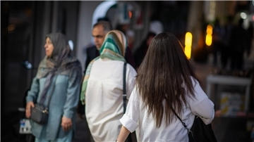 Eine Frau läuft mit offenen Haaren durch Teheran.
