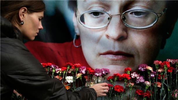 Mordfall Politkowskaja: Täter kommt für Kriegseinsatz frei Eine Frau legt in Moskau Blumen vor einem Porträt der ermordeten russischen Journalistin Anna Politkowskaja nieder.