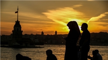 Eine Frau mit Kopftuch steht in Istanbul an der Meerenge Bosporus.