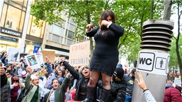 Eine Frau schneidet sich in Hamburg demonstrativ die Haare ab, um sich mit den Frauen im Iran zu solidarisieren.