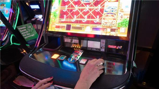 Viele Bremer Spielhallen bekommen keine Betriebserlaubnis Eine Frau sitzt in einer Spielhalle vor einem Automatenspiel.
