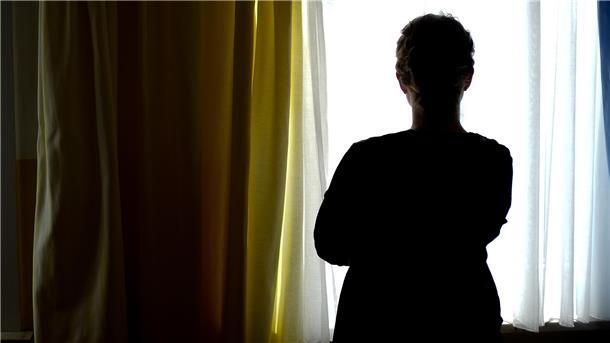 Eine Frau steht in einem Zimmer eines Frauenhauses. Betroffene von häuslicher Gewalt finden in solchen Einrichtungen Schutz. Für die Wesermarsch ist das Frauenhaus Ammerland-Wesermarsch die Anlaufstelle.