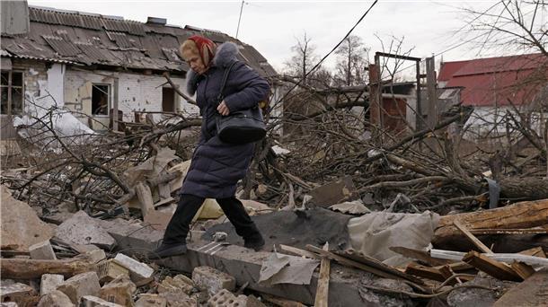 Krieg gegen die Ukraine: So ist die Lage Eine Frau steigt in Kiew über Trümmer von Gebäuden.