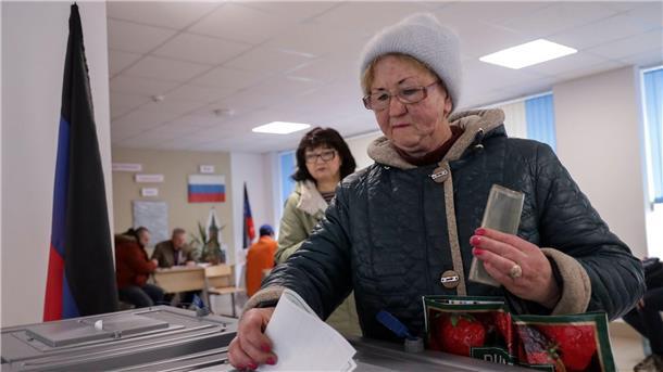 Russlands Wahlkommission spricht Putin Rekordergebnis zu Eine Frau wählt in einem Wahllokal in Mariupol in der russisch kontrollierten Region Donezk im Osten der Ukraine.