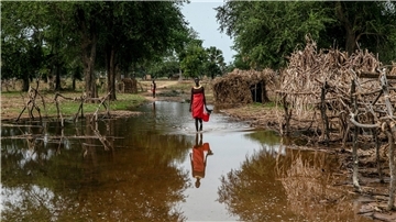 Eine Frau watet durch das Hochwasser zwischen verlassenen Unterkünften im Dorf Majak Awar im Südsudan. Dort sind ganze Bundesstaaten überflutet. Sieben der zehn Klimakrisenherde, die die Nichtregierungsorganisation Oxfam in einer aktuellen Studie identifiziert hat, liegen in Afrika.