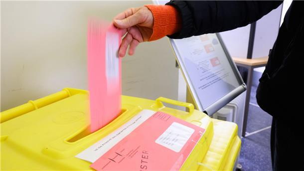 Eine Frau wirft ihren Wahlzettel für die Bundestagswahl 2025 in der Briefwahlstelle im Neuen Rathaus in eine Urne. 